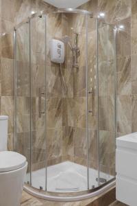 a shower stall in a bathroom with a toilet at Modern city centre studio apartment 202 in Oxford