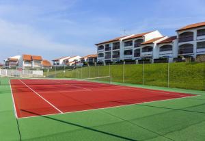 um campo de ténis em frente a alguns complexos de apartamentos em Zirlingua Bidart - magnifique appartement 2 pieces em Bidart
