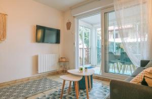 uma sala de estar com uma mesa e uma televisão em Zirlingua Bidart - magnifique appartement 2 pieces em Bidart