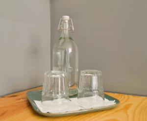 una botella de cristal y dos vasos en una mesa en Feeling Parque 56, en Lisboa