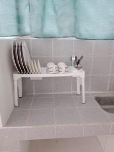 una pequeña mesa blanca con platos y utensilios. en HOTEL SAN MARINO TUMACO, en Tumaco