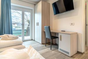 a bedroom with a desk and a bed and a window at B&B A Un Passo Dal Lago, Caldonazzo in Caldonazzo