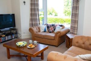 a living room with a couch and a coffee table at Glenydd Rhydlewis in Rhyd Lewis