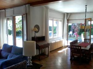 uma sala de estar com um sofá azul e janelas em Casa Vintage delante del mar para 15 huéspedes em San Vicente de Calders