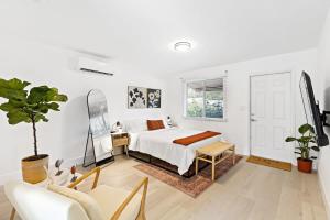 a white bedroom with a bed and a table and chair at Lovely Rental Unit with free Parking on Premises in Fort Lauderdale