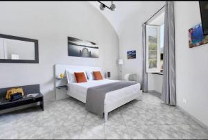 a white bedroom with a bed and a window at Sorrento Realty Holidays Nagy House in Sant'Agnello