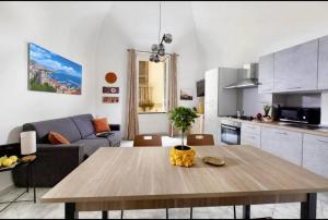 a kitchen and a living room with a wooden table at Sorrento Realty Holidays Nagy House in Sant'Agnello