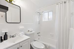 a white bathroom with a toilet and a sink at Lovely Rental Unit with free Parking on Premises in Fort Lauderdale +10 photos