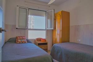 1 dormitorio con 2 camas y ventana en Apartamento, Sol y Playas, en Benalmádena
