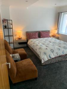 1 dormitorio con 1 cama, 1 silla y 1 sofá en Luton Lodge - Near London Luton Airport Luxury Quite Rooms Close to Restaurants & Shops en Luton