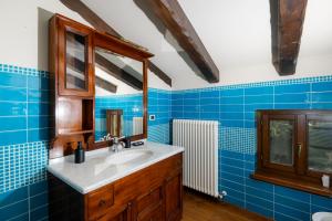 Baño de azulejos azules con lavabo y espejo en 1448 Antica Dimora Al Merlo Bianco, en Cividale del Friuli