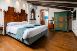 奇維達萊德爾夫留利的住宿－1448 Antica Dimora Al Merlo Bianco，一间卧室配有一张大床和木制床头板