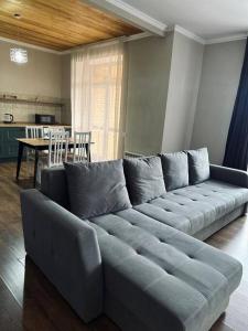 a large couch in a living room with a table at Элитные современные апартаменты с гостиничным сервисом in Karagandy