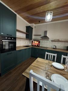 a kitchen with green cabinets and a wooden table at Элитные современные апартаменты с гостиничным сервисом in Karagandy