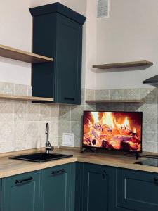 a kitchen with a tv with a fire on the wall at Элитные современные апартаменты с гостиничным сервисом in Karagandy