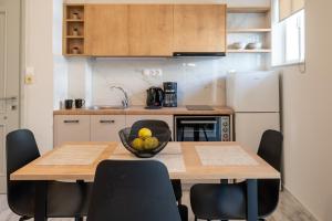 a kitchen with a table with a bowl of fruit on it at Mardinik Hotel Apartments in Rethymno +94 photos