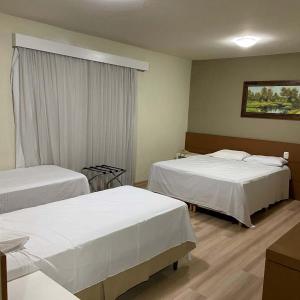 ein Hotelzimmer mit 2 Betten und einem Fenster in der Unterkunft Hotel Guest in Venâncio Aires
