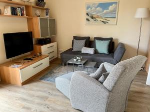 uma sala de estar com um sofá e uma televisão em Ferienwohnung-Voigt em Westerland