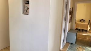a hallway with a white wall and a table at Eirini Home in Andros