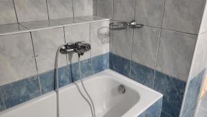 a bath tub with a shower head in a bathroom at Eirini Home in Andros