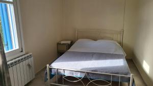 a bed in a small room with a window at Eirini Home in Andros