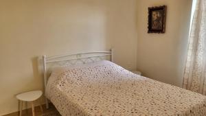 a bedroom with a bed with a floral bedspread at Eirini Home in Andros