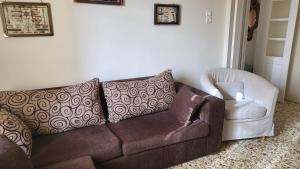 a living room with a brown couch and a white chair at Eirini Home in Andros