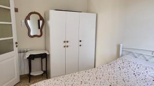 a bedroom with a white cabinet next to a bed at Eirini Home in Andros