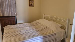 a bed with a striped blanket on it in a bedroom at Eirini Home in Andros