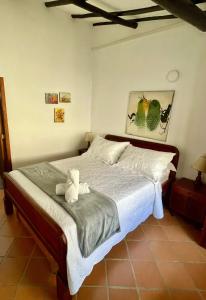 a bedroom with a bed with two stuffed animals on it at Hotel-Apartahotel Boutique Piedra & Luna in Villa de Leyva