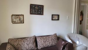a living room with a couch and three pictures on the wall at Eirini Home in Andros
