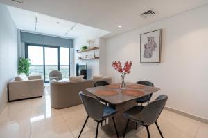 een eetkamer en een woonkamer met een tafel en stoelen bij Appartement Dubai in Dubai