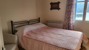 a bedroom with a bed and a chair and a window at Eirini Home in Andros