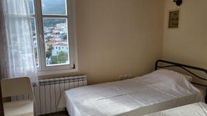 a small bedroom with a bed and a window at Eirini Home in Andros