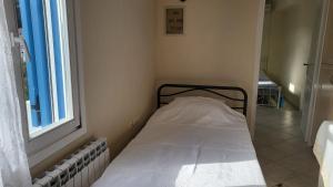 a small bed in a room with a window at Eirini Home in Andros