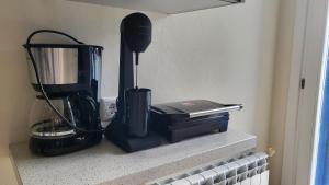 a kitchen counter with a blender on a shelf at Eirini Home in Andros