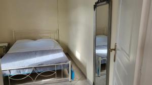 a small bedroom with a bed and a mirror at Eirini Home in Andros