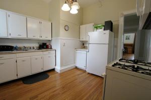 een keuken met witte kasten en een witte koelkast bij Home Run Apt 2 All Star Baseball Rentals in Oneonta