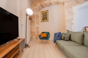 a living room with a couch and a flat screen tv at Massaroom a Corte in Conversano