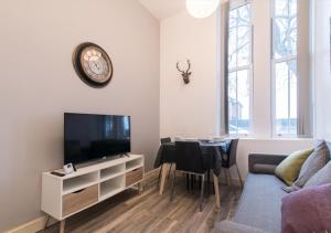 a living room with a television and a dining room table at Derby Osmaston 1 Bedroom Apartment w/Free Parking in Derby