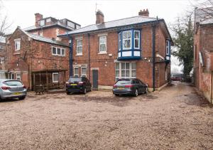 three cars parked in front of a brick building at Derby Osmaston 1 Bedroom Apartment w/Free Parking in Derby