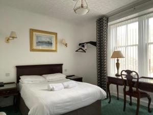 1 dormitorio con 1 cama con 2 toallas en Argyll Arms Hotel, en Campbeltown