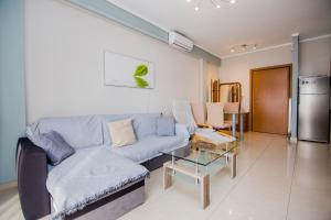 a living room with a blue couch and a table at Apartment near the circuit of Serres and centre!!! in Serres