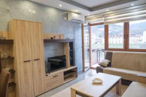 a living room with a television and a couch and a table at Apartmani Bašta in Višegrad