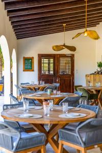 a restaurant with wooden tables and blue chairs at Boutique Hotel Wanapa in Kralendijk