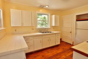 a kitchen with white cabinets and a sink and a window at The Hill All Star Baseball Rentals in Oneonta