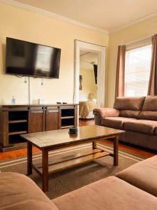 een woonkamer met een salontafel en een flatscreen-tv bij Home Run Apt 1 All Star Baseball Rentals in Oneonta