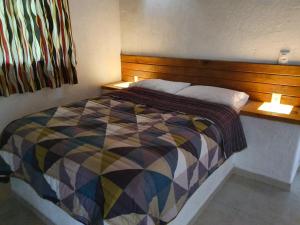 um quarto com uma cama com uma cabeceira de madeira em Hotel Rancho Escondido em Valle de Bravo