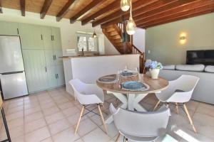 a living room with a table and white chairs at Les Gîtes de l'étang de la forêt in Brandivy +17 photos