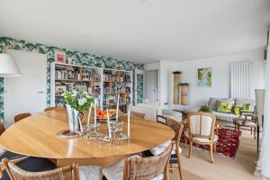 a dining room with a wooden table and chairs at Magnifique appartement sur parc in Paris